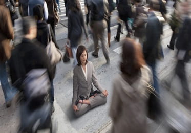 a woman in a business suit meditating in a crowd